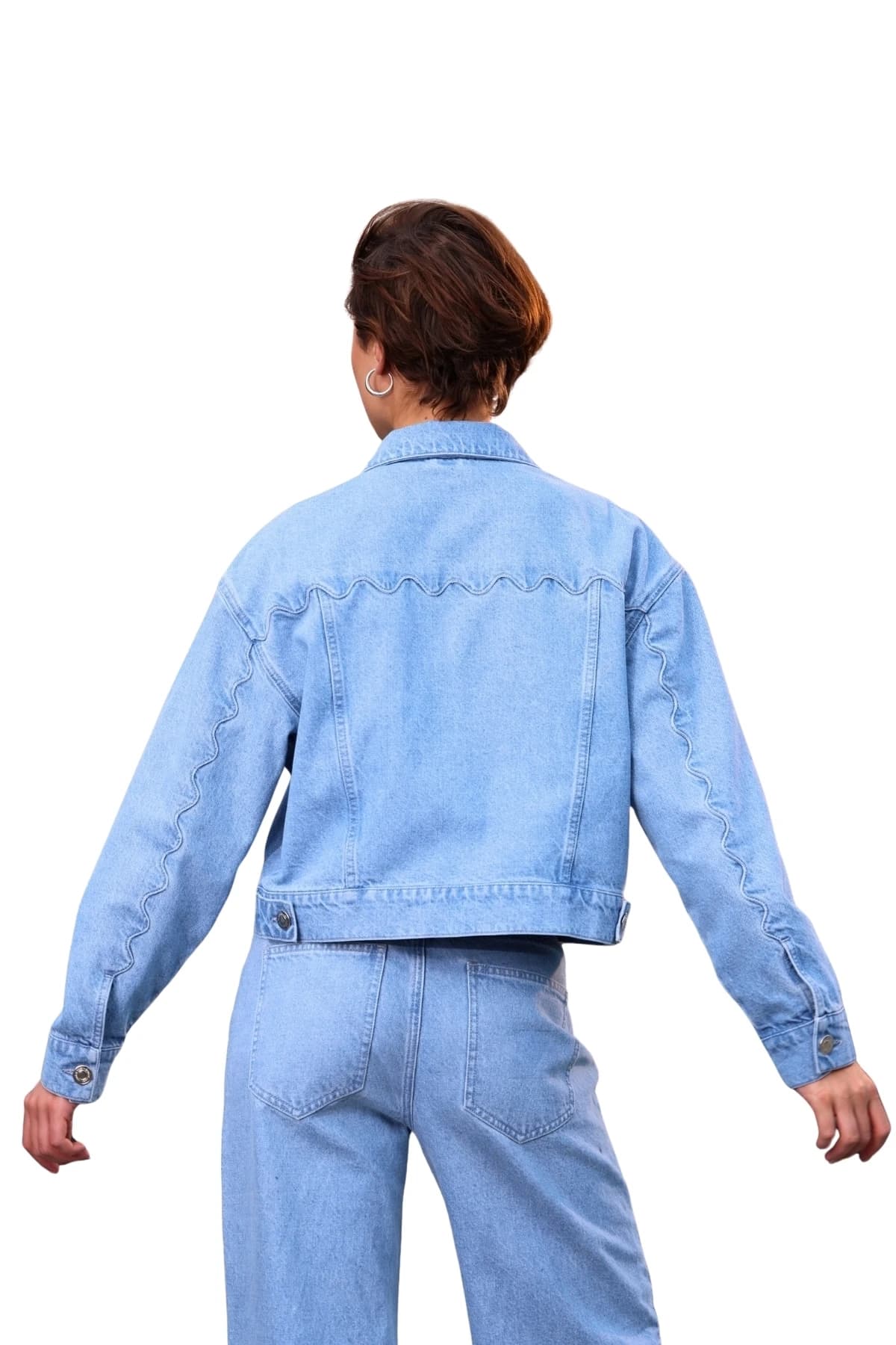 Denim Moon kadın açık mavi kısa kesim denim ceket, dalgalı dikişli sırt robası ve düğmeli bel bandıyla modelde arkadan tam boy görünüm.
