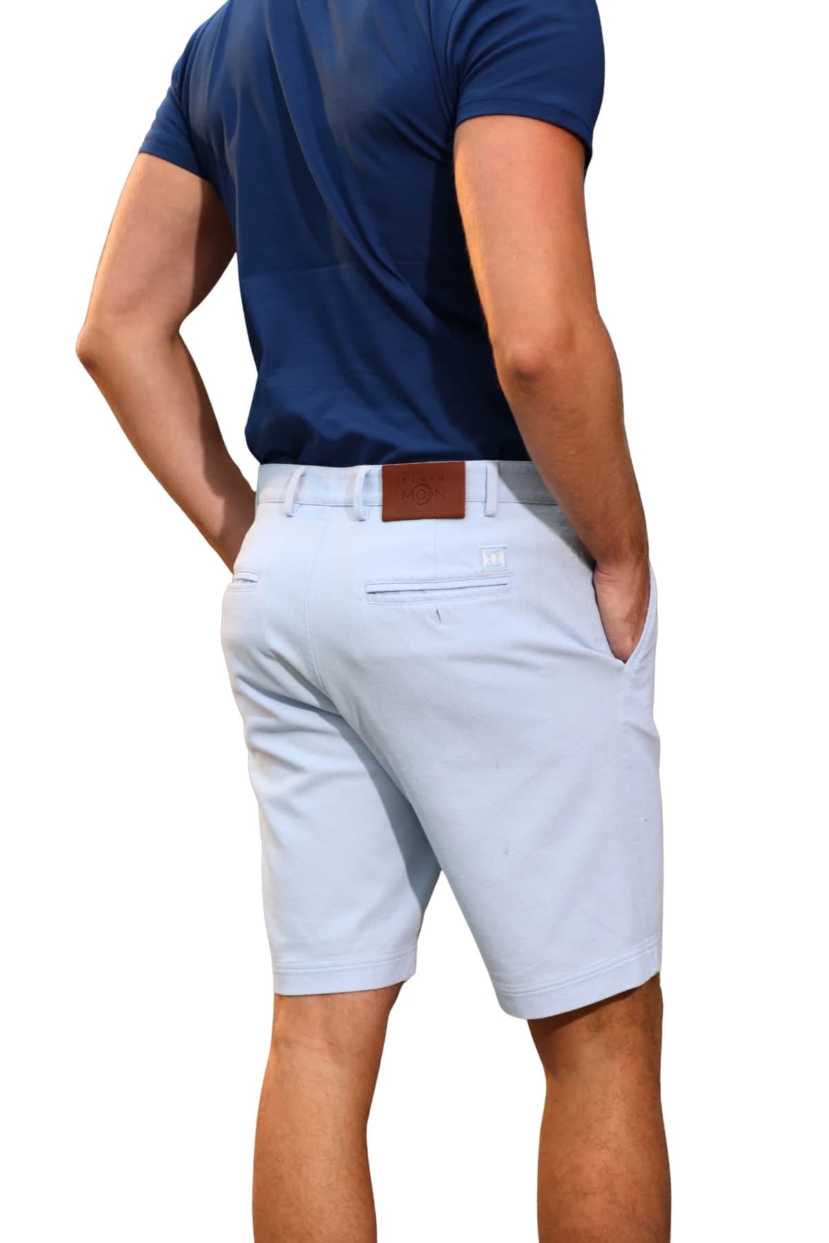 Denim Moon men's light blue woven chino shorts with back pocket and waist label detail, angled close-up back view on model.