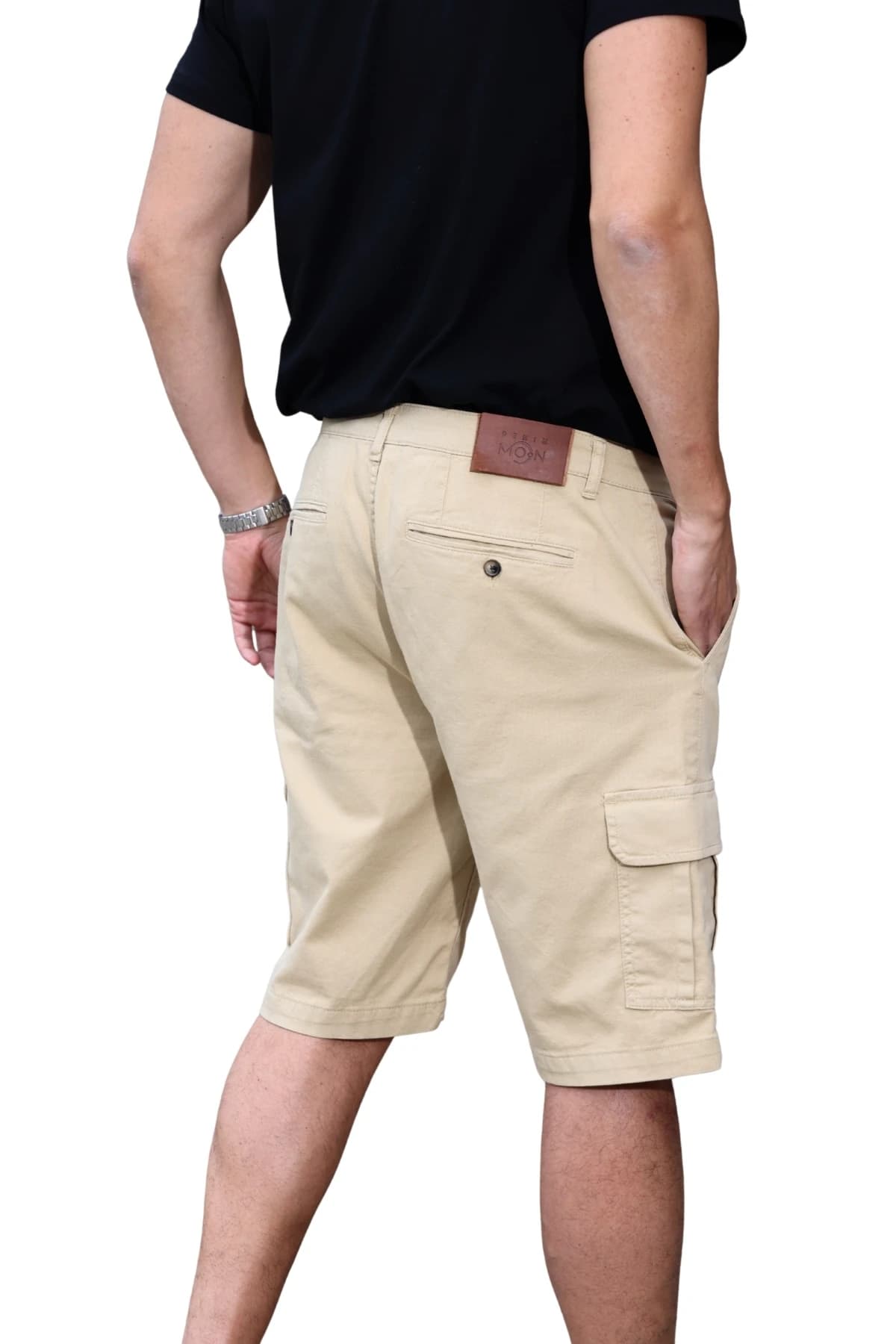 Denim Moon men's beige woven cargo shorts with buttoned back pocket and leather waist label detail, close-up back view on model.