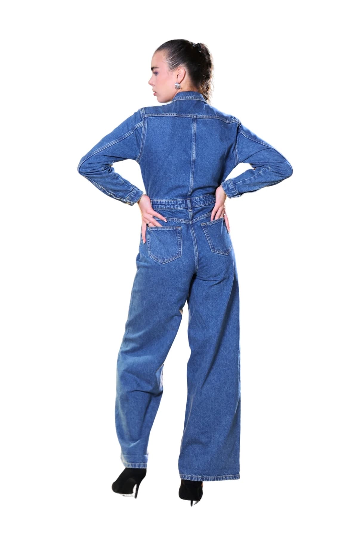 Denim Moon kadın mavi denim tulum, arka cepler ve geniş paça kesim, modelde arkadan tam boy görünüm.