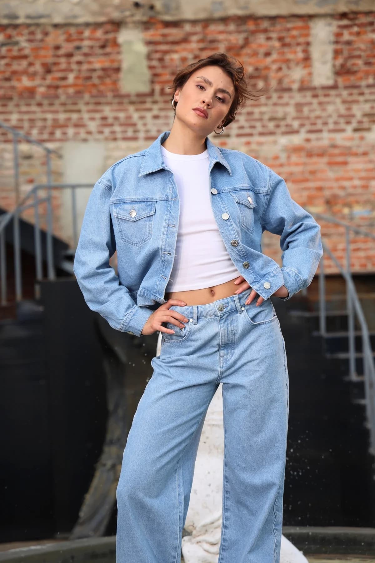 Denim Moon kadın açık mavi yıkamalı kapaklı cepli crop oversize denim ceket, modelde elleri belde önden görünüm.