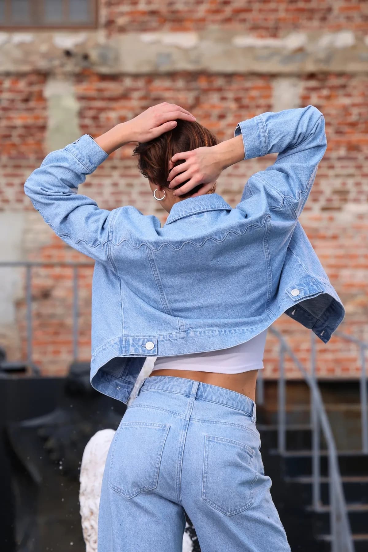Denim Moon kadın açık mavi crop denim ceket, sırt robasındaki dalgalı dikiş ve düğmeli bel patıyla arkadan görünüm.