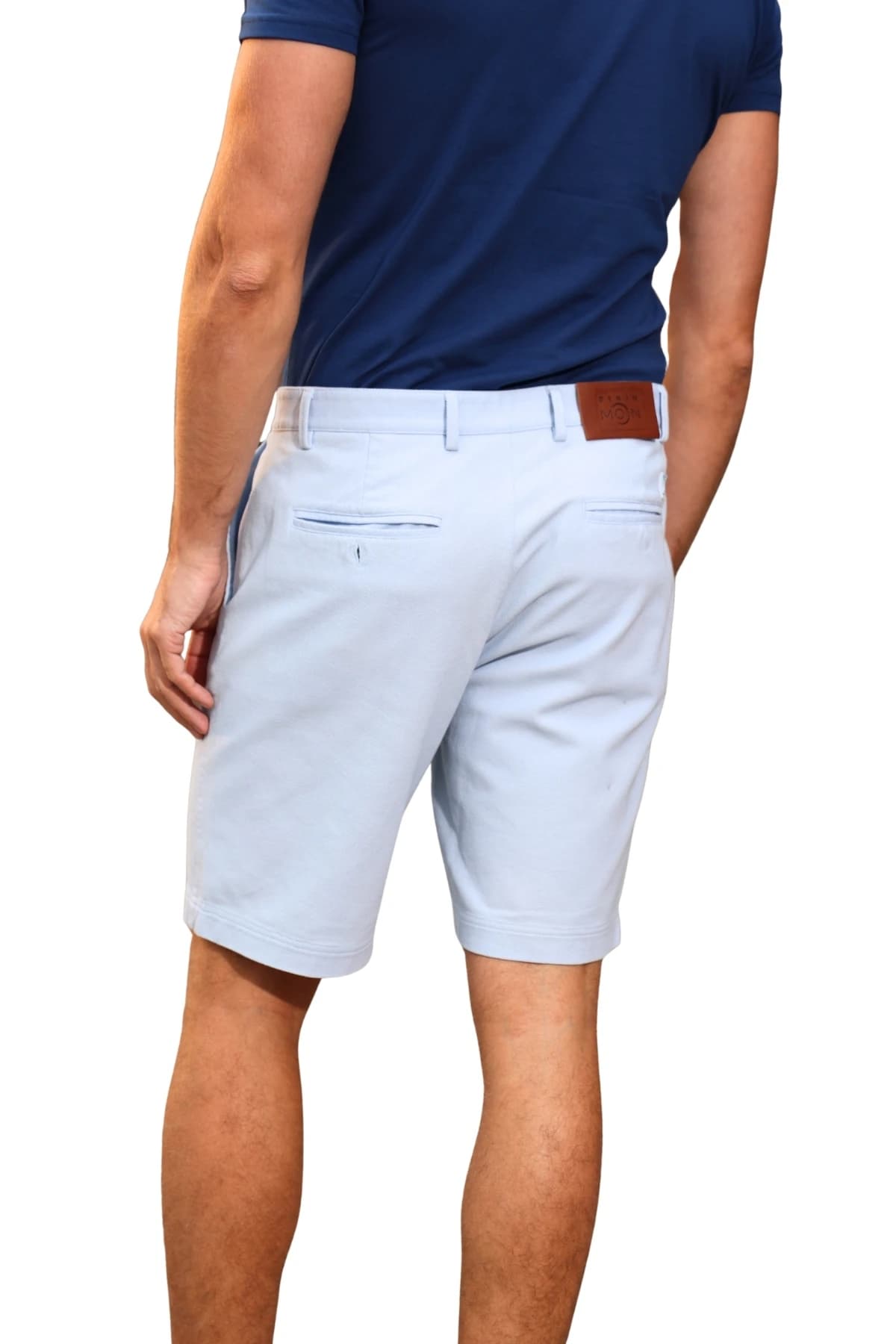 Denim Moon men's light blue woven chino shorts with buttoned back pocket and leather waist label detail, close-up back view on model.